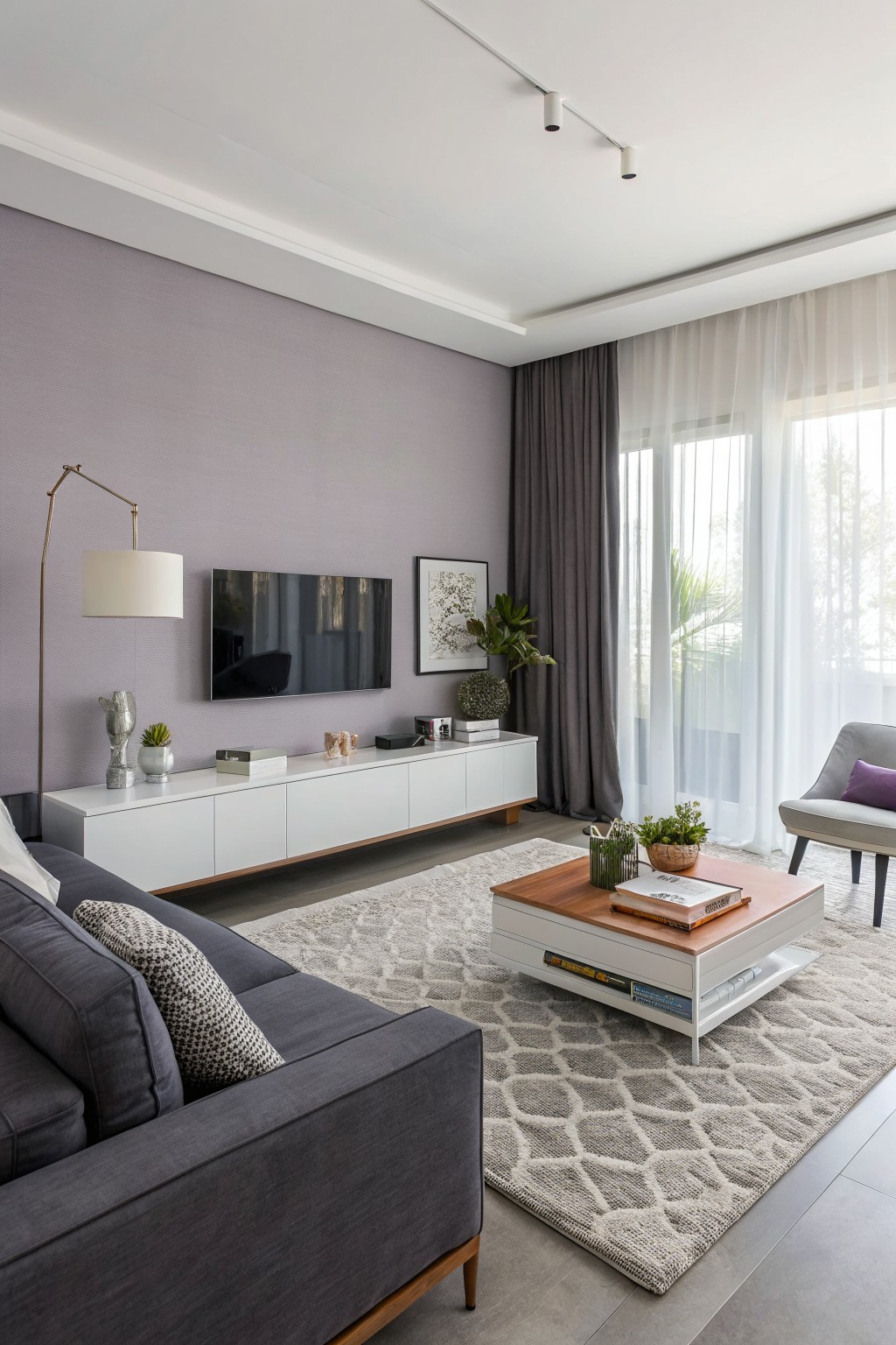 Living room with soft lavender-gray accent wall behind white media console and TV, gray sofa, wood coffee table, and sheer curtains over balcony doors