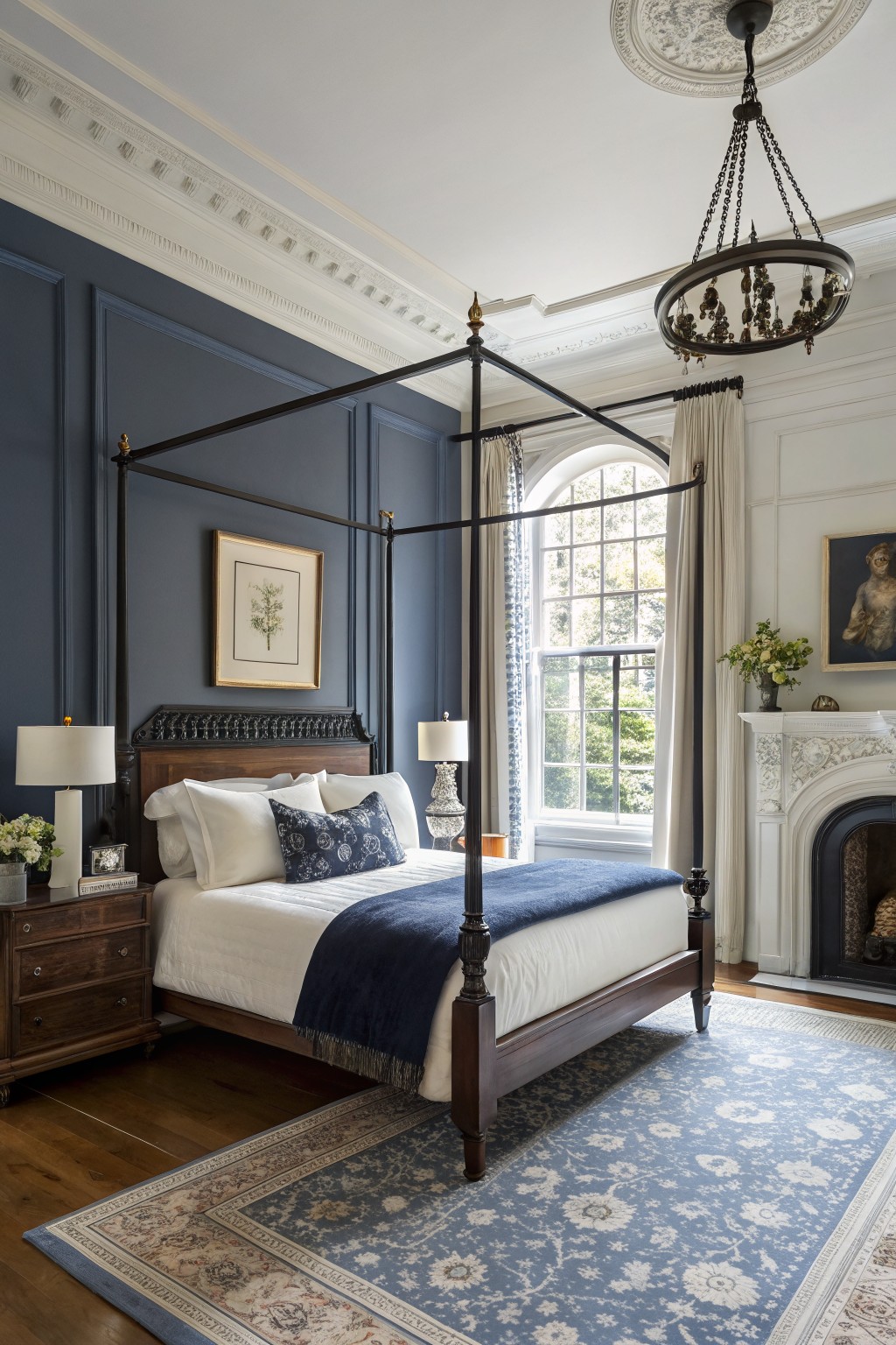 Bedroom featuring deep navy paneled walls beside white trim, a dark wood four-poster bed, and arched window with sheer curtains