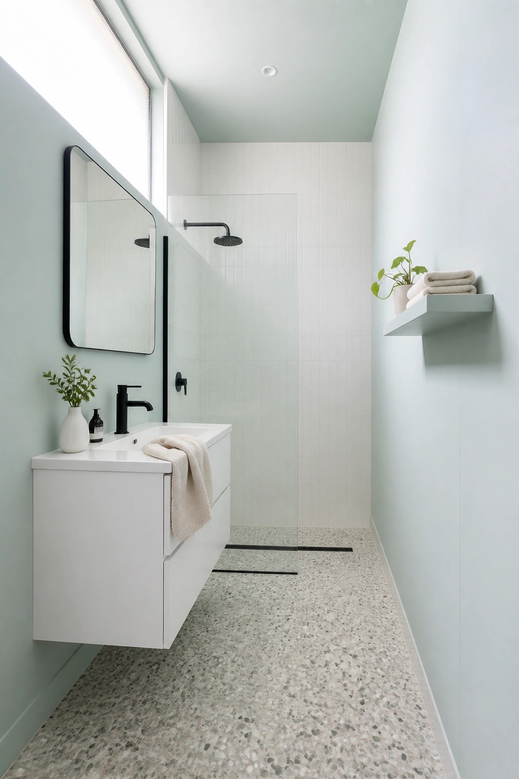 Bathroom walls painted soft sage green with a white floating vanity.