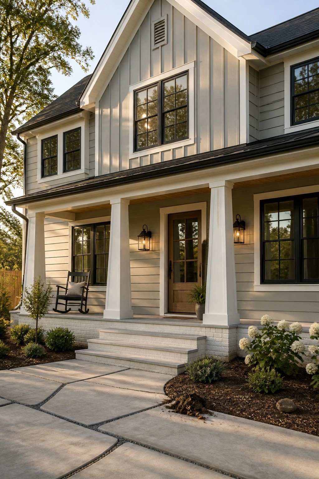A house exterior painted in soft gray siding with white trim and black windows.