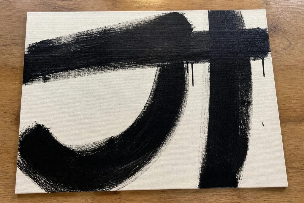 18 Bold Black and White Abstract Painting Ideas for Timeless Contrast Abstract black brushstrokes on white canvas atop wooden table
