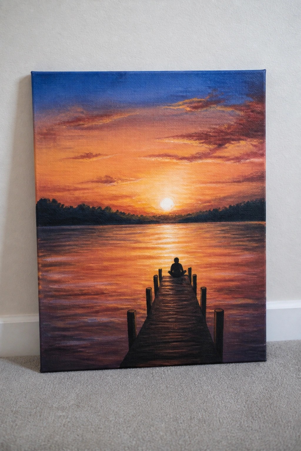 Painting of silhouetted figure seated on wooden dock at vibrant orange sunset over water.