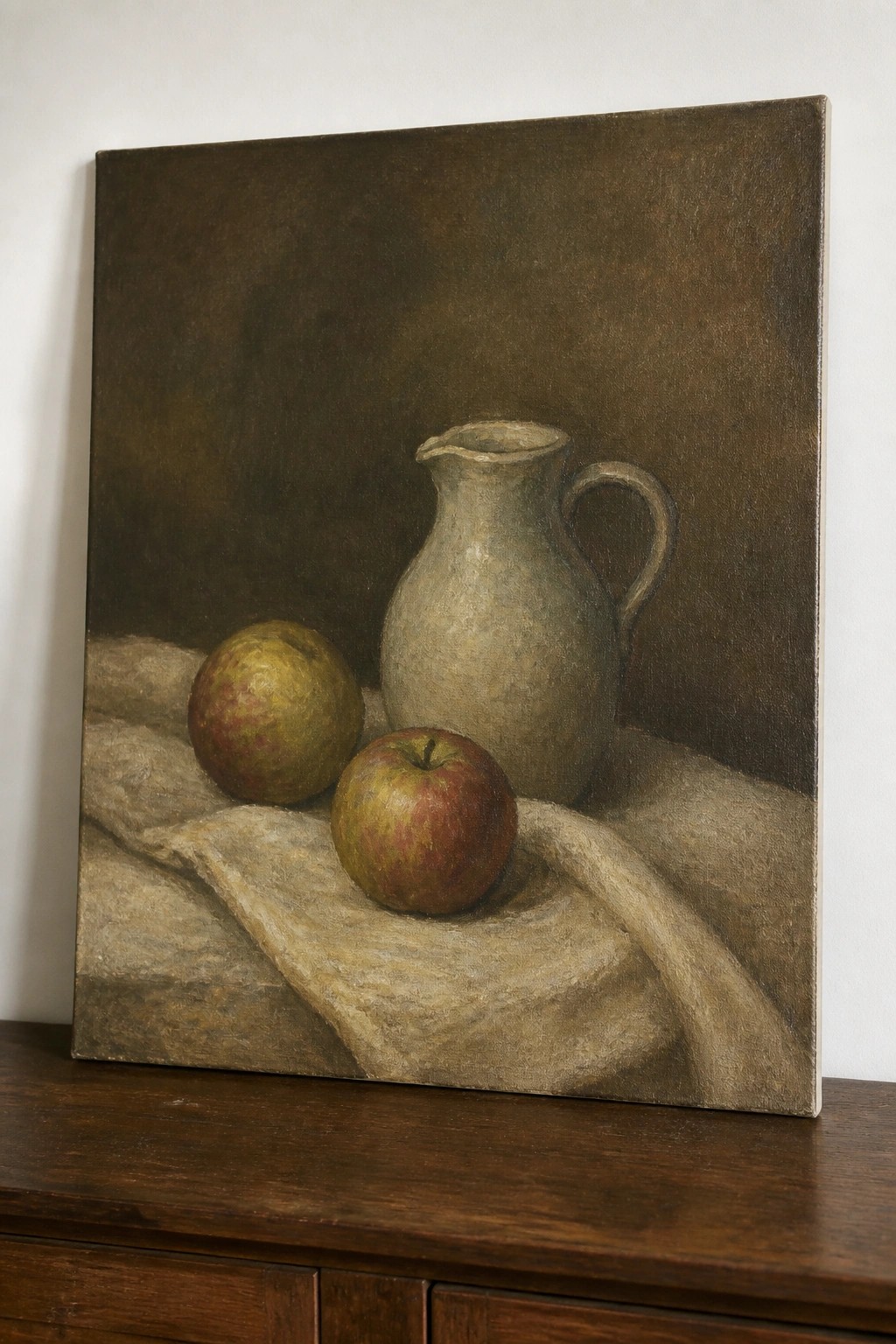 Still life painting of two apples and a ceramic pitcher on draped cloth