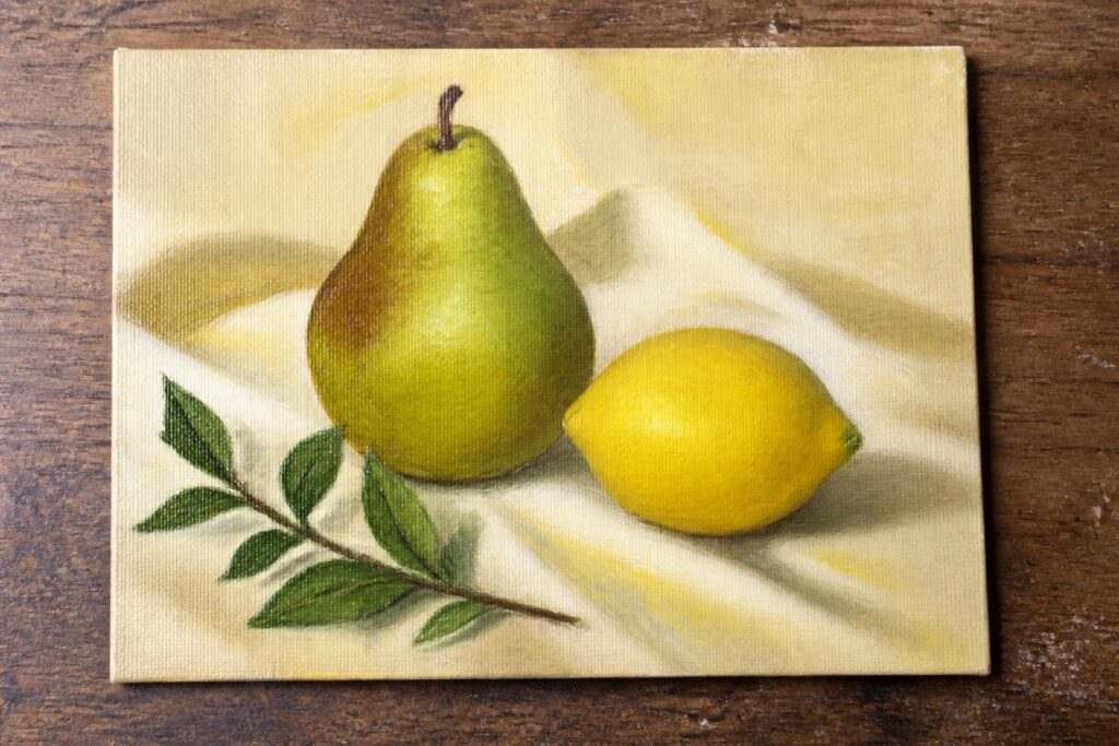 Yellow-green pear and lemon with leaves on draped fabric in still life painting