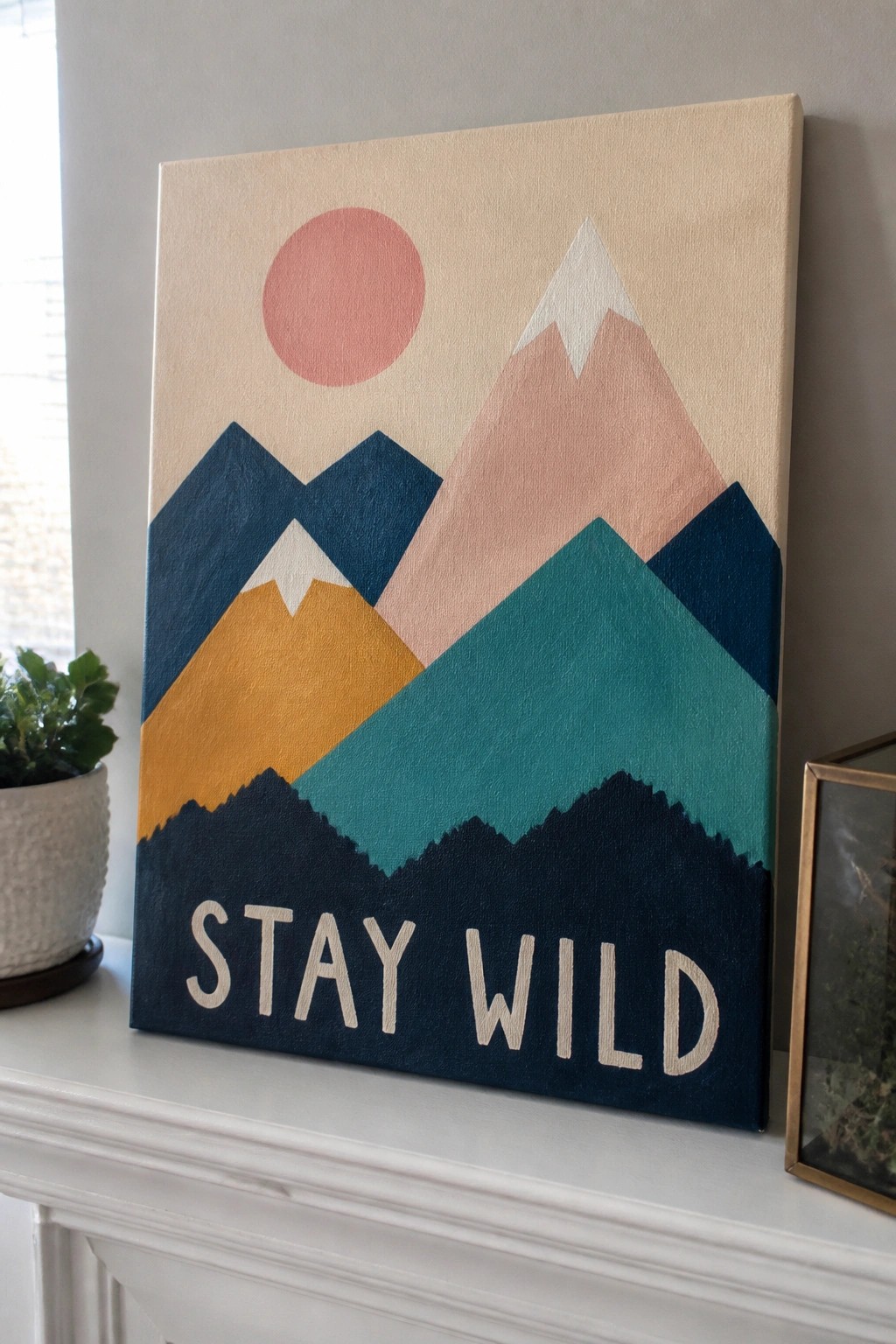 Modern abstract canvas art of colorful mountains with pink sun and stay wild text