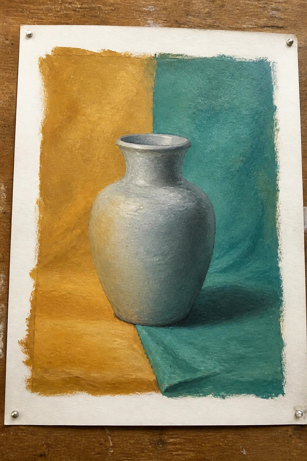 Gray vase on teal cloth against yellow and teal painted background