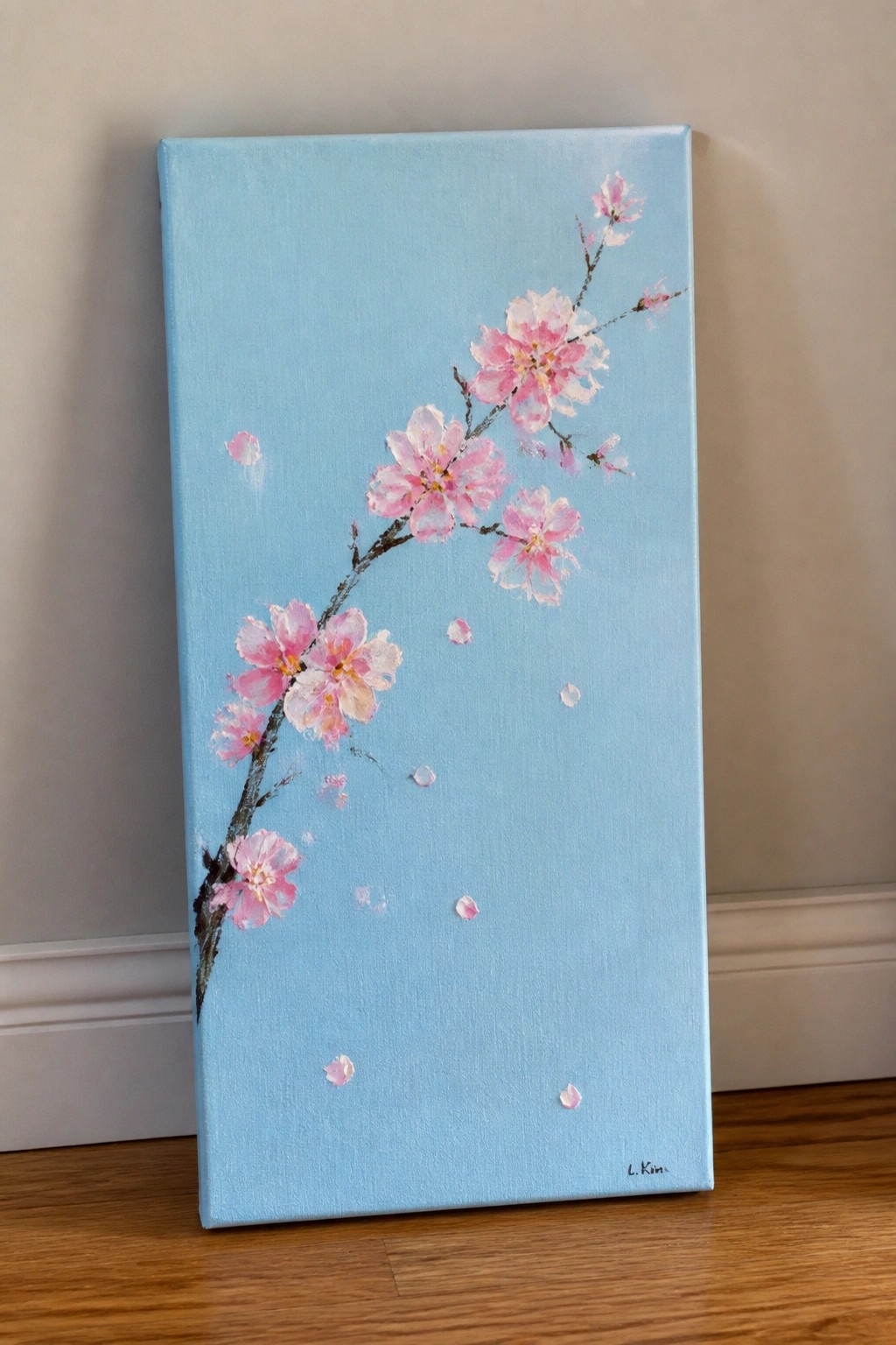 Pink cherry blossom branch with falling petals on light blue canvas painting