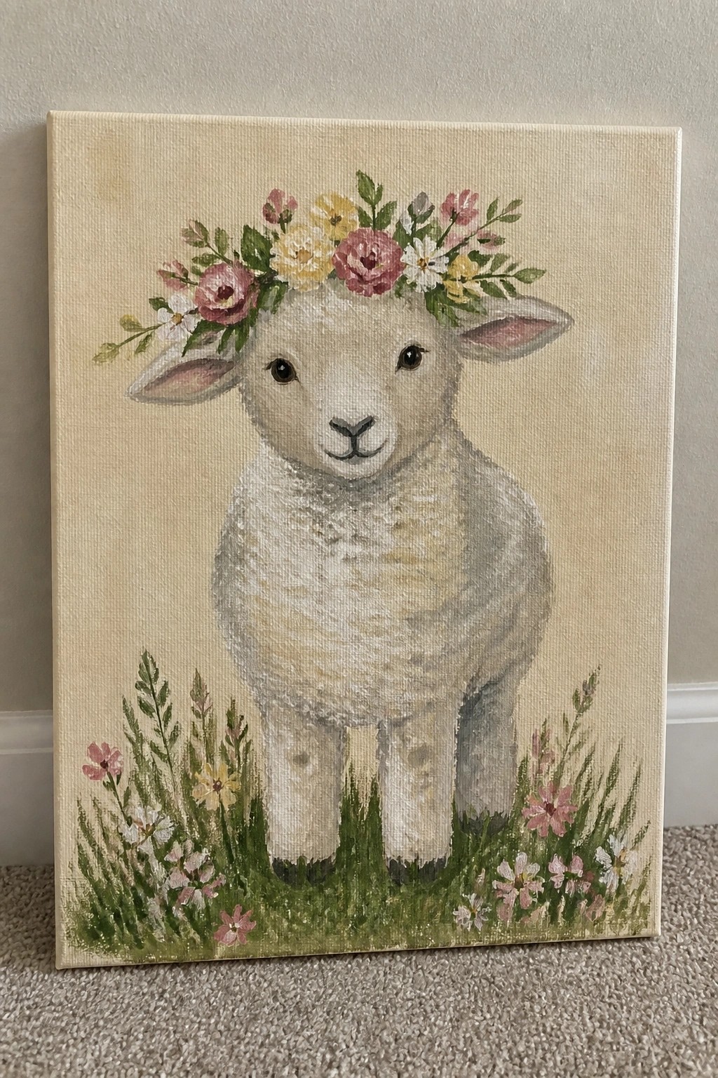 Painted canvas of fluffy white lamb with pink-yellow flower crown in grass.
