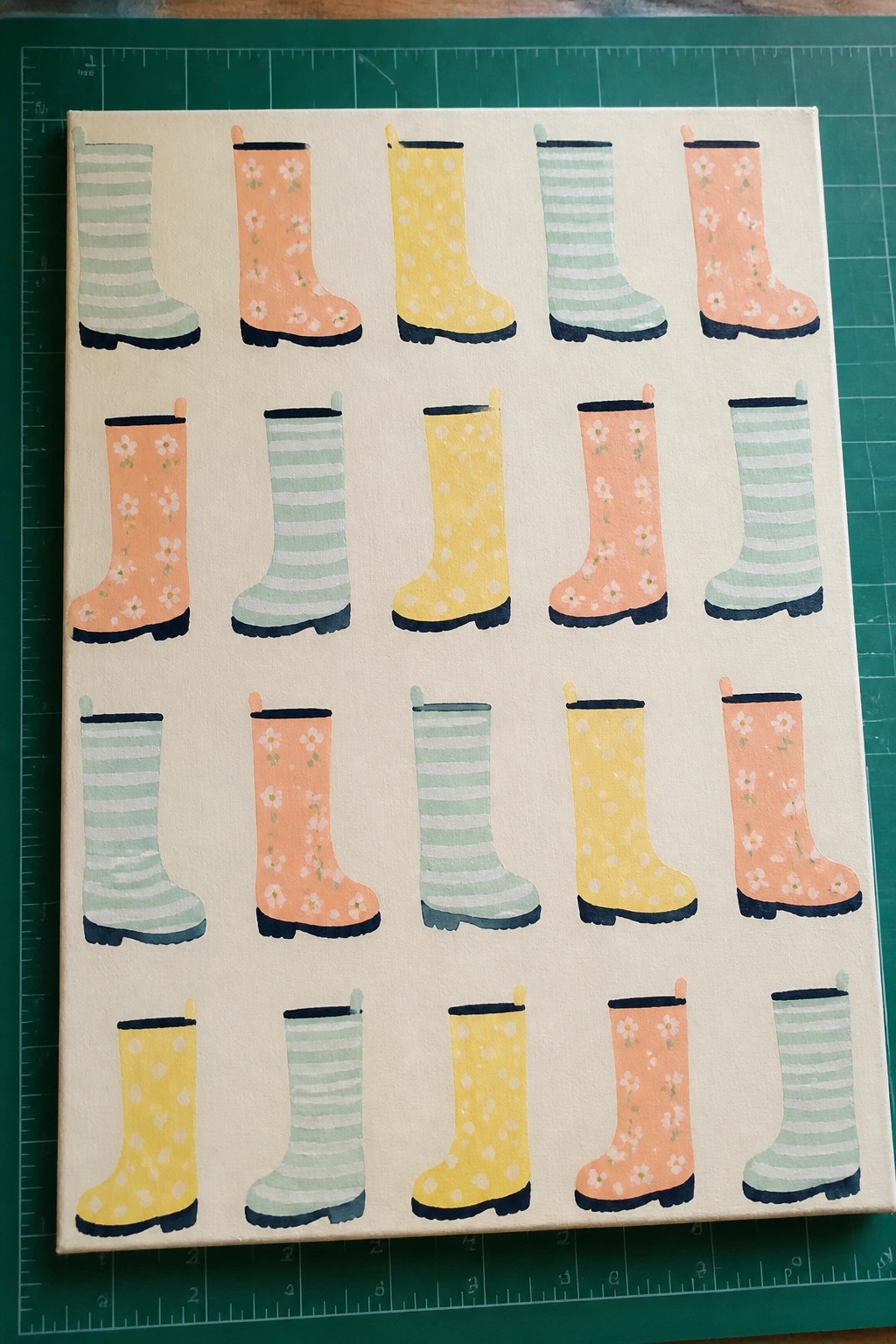 Canvas painting of colorful patterned rain boots in rows on beige background
