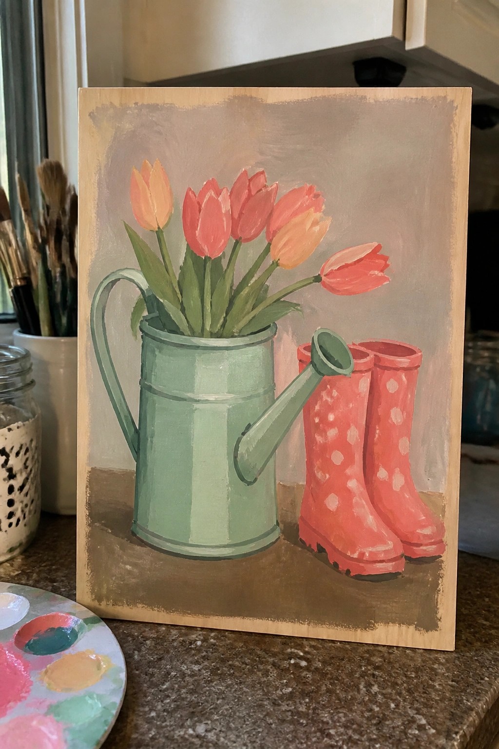 Acrylic painting of coral tulips in green watering can beside red polka-dot boots.
