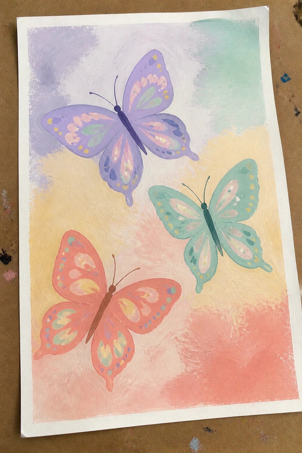 Three watercolor butterflies in purple, teal, and coral on a pastel gradient background