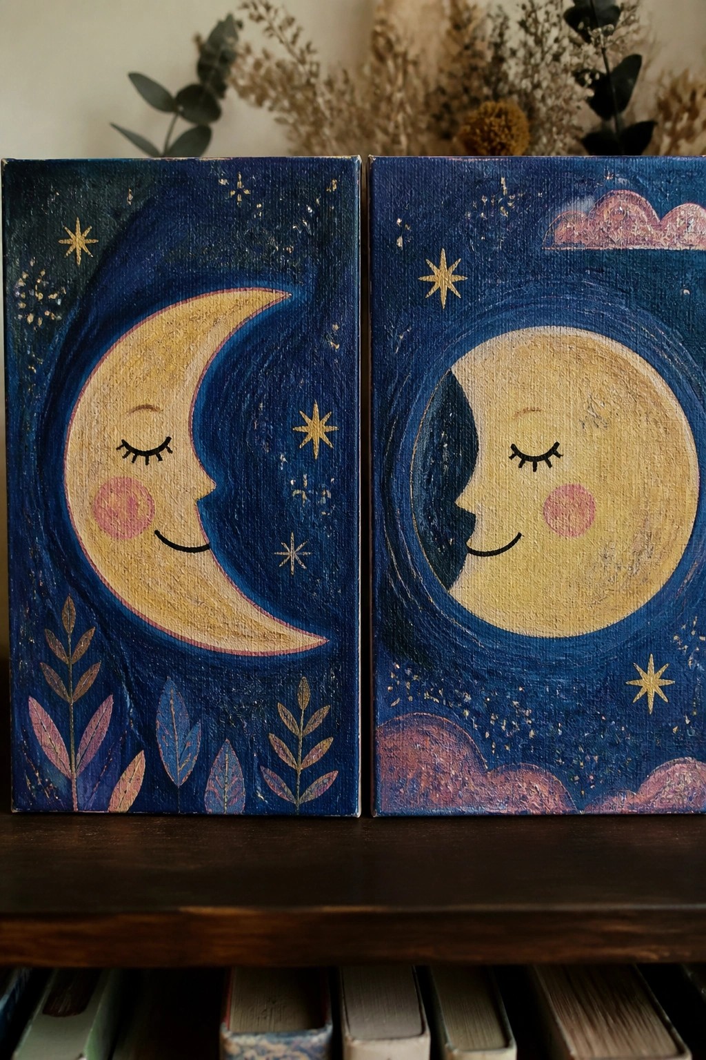 Two canvas paintings side by side showing a crescent moon with a face on the left and a full moon with a face on the right, both in a starry blue night scene.
