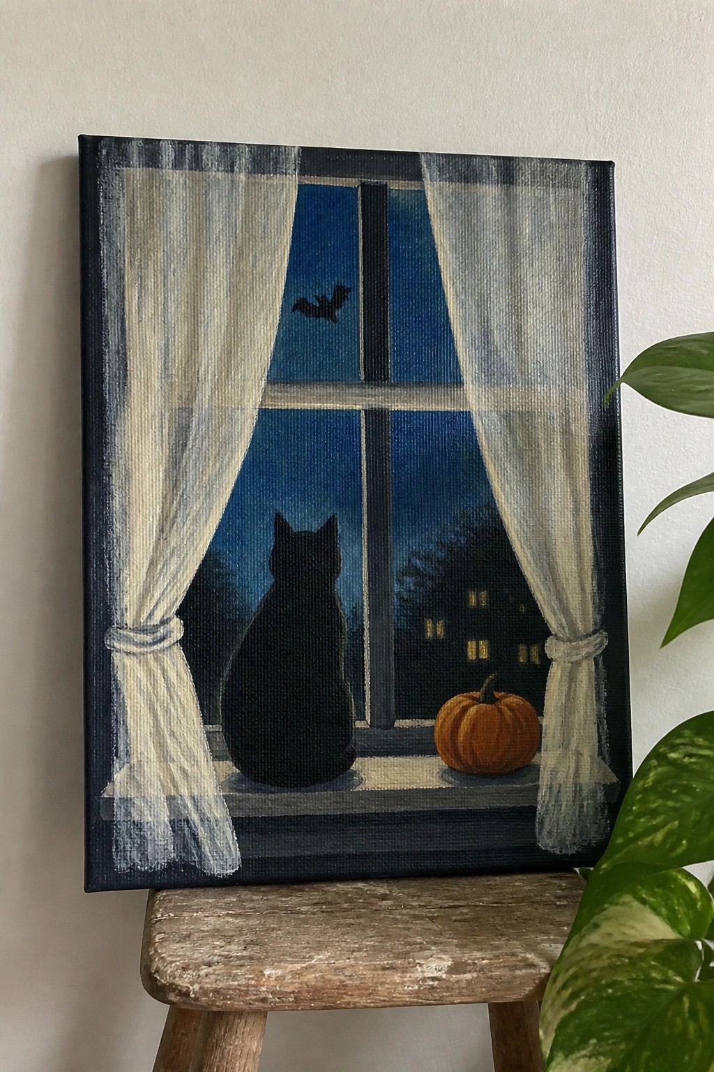 Black cat on windowsill with pumpkin, bat flying in night sky