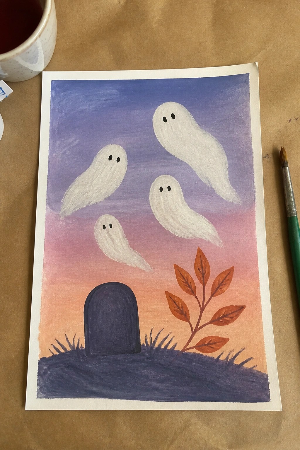 Watercolor painting of four ghosts floating over a tombstone and autumn leaves at dusk