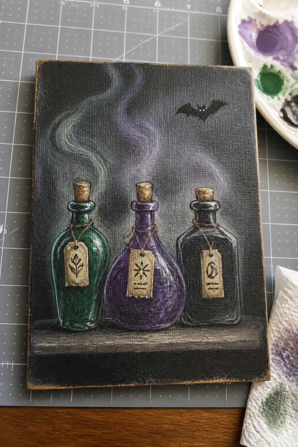 Three labeled potion bottles in green, purple, black with swirling smoke and bat.