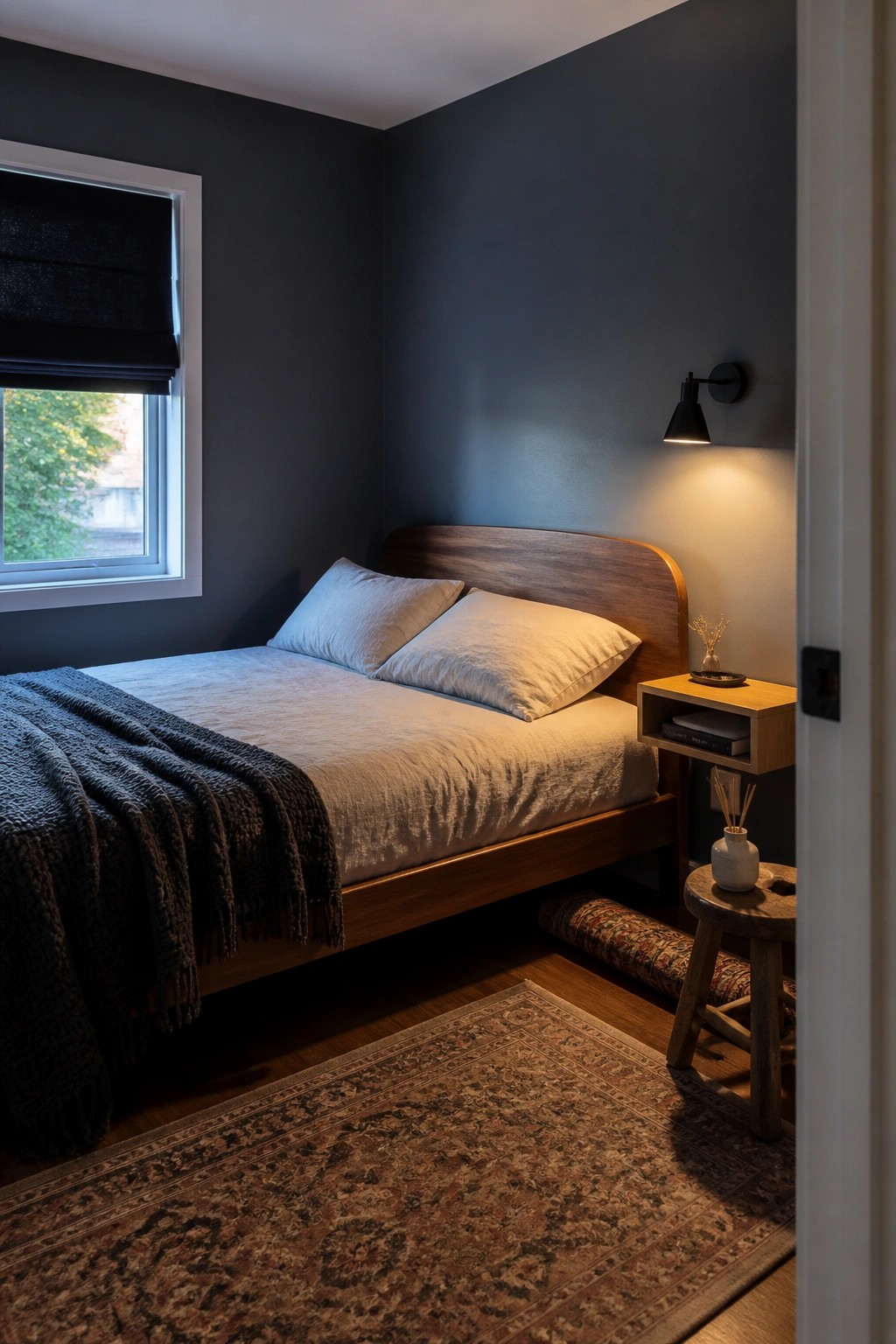 Dark blue-gray walls in a small bedroom with a wooden bed frame and warm wood accents.