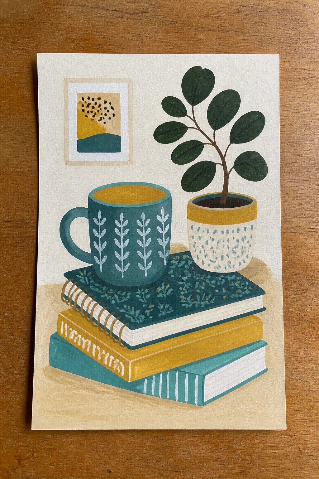 Watercolor illustration of stacked books with patterned mug, potted plant, and framed art.