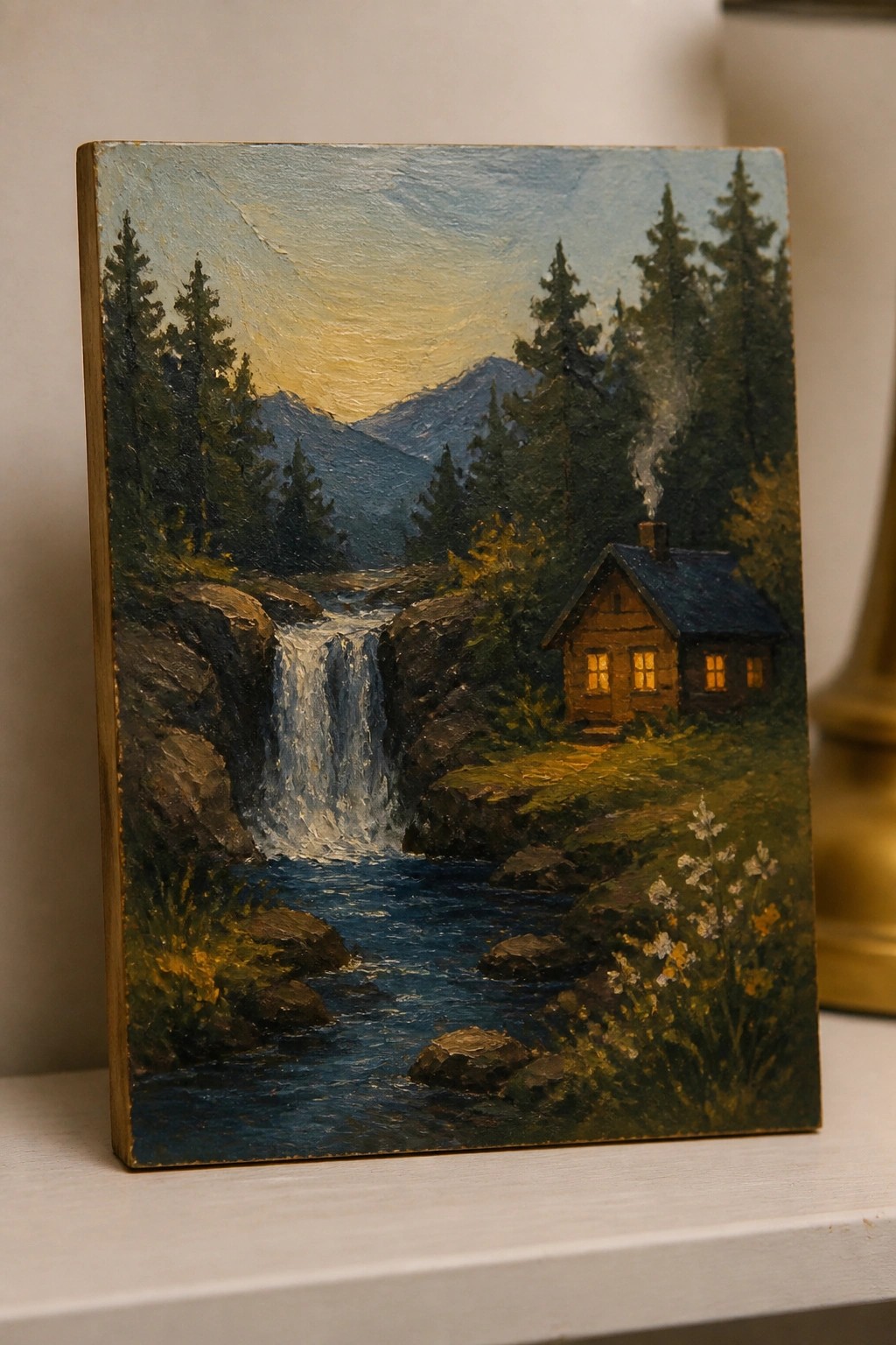 Oil painting of a log cabin with glowing windows by a waterfall in mountains.