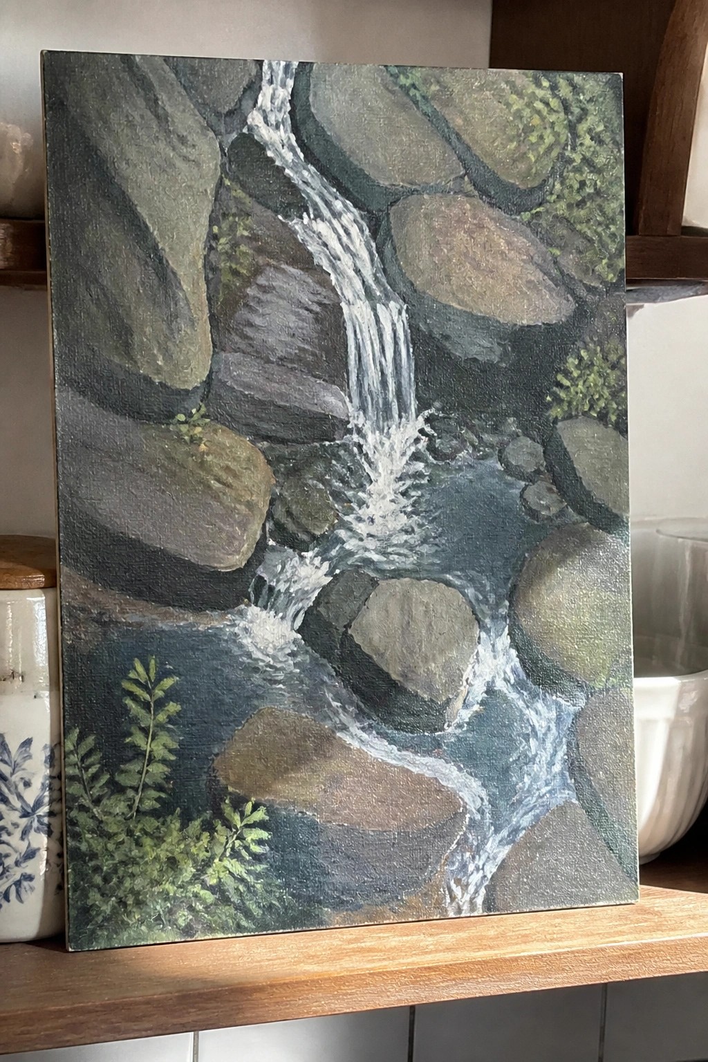 Realistic painting of cascading waterfall over mossy rocks into winding blue stream.