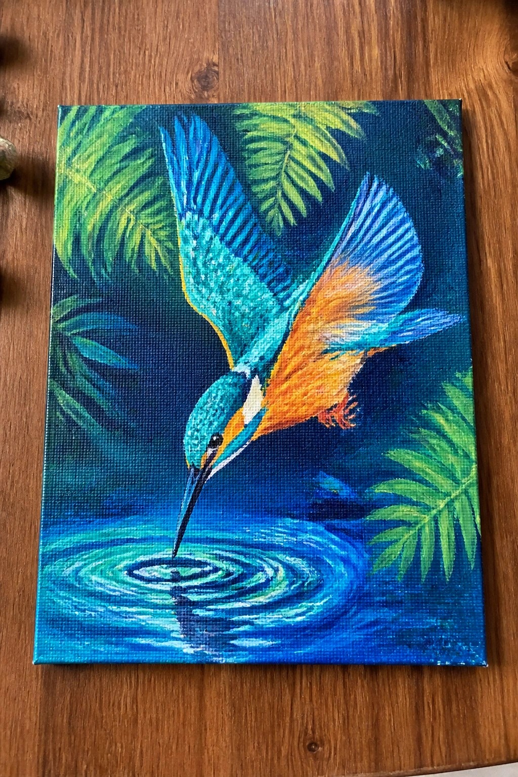 Vibrant kingfisher painting with blue-orange wings diving into rippling turquoise water amid green leaves