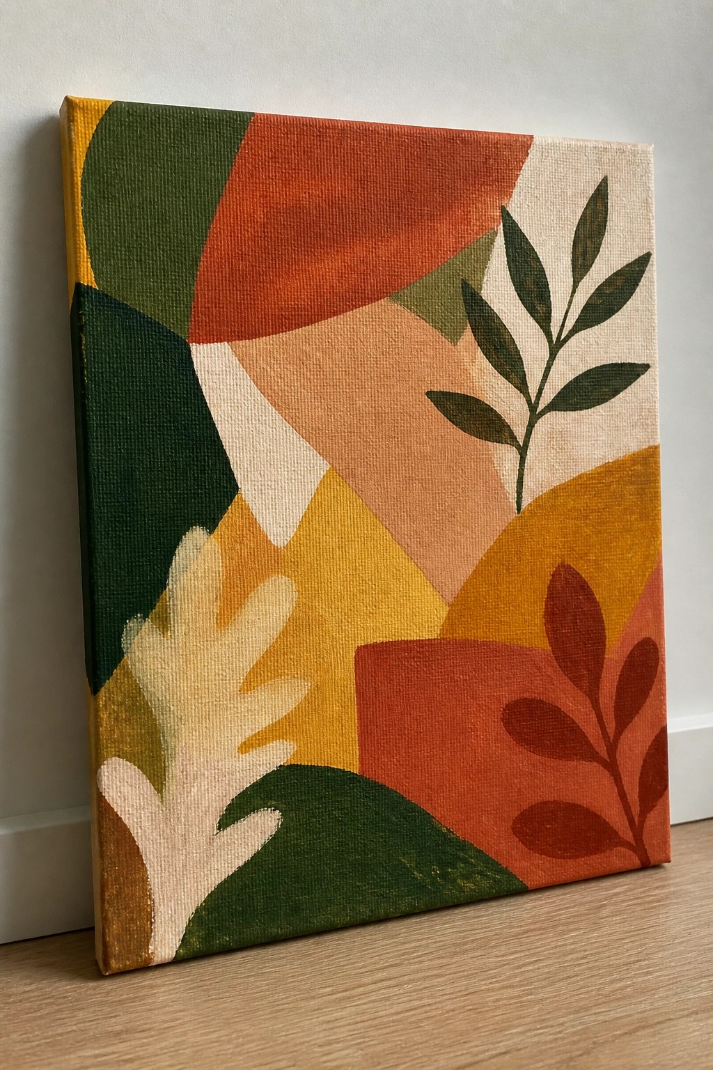 Abstract canvas with colorful geometric shapes and botanical leaf motifs in warm tones.