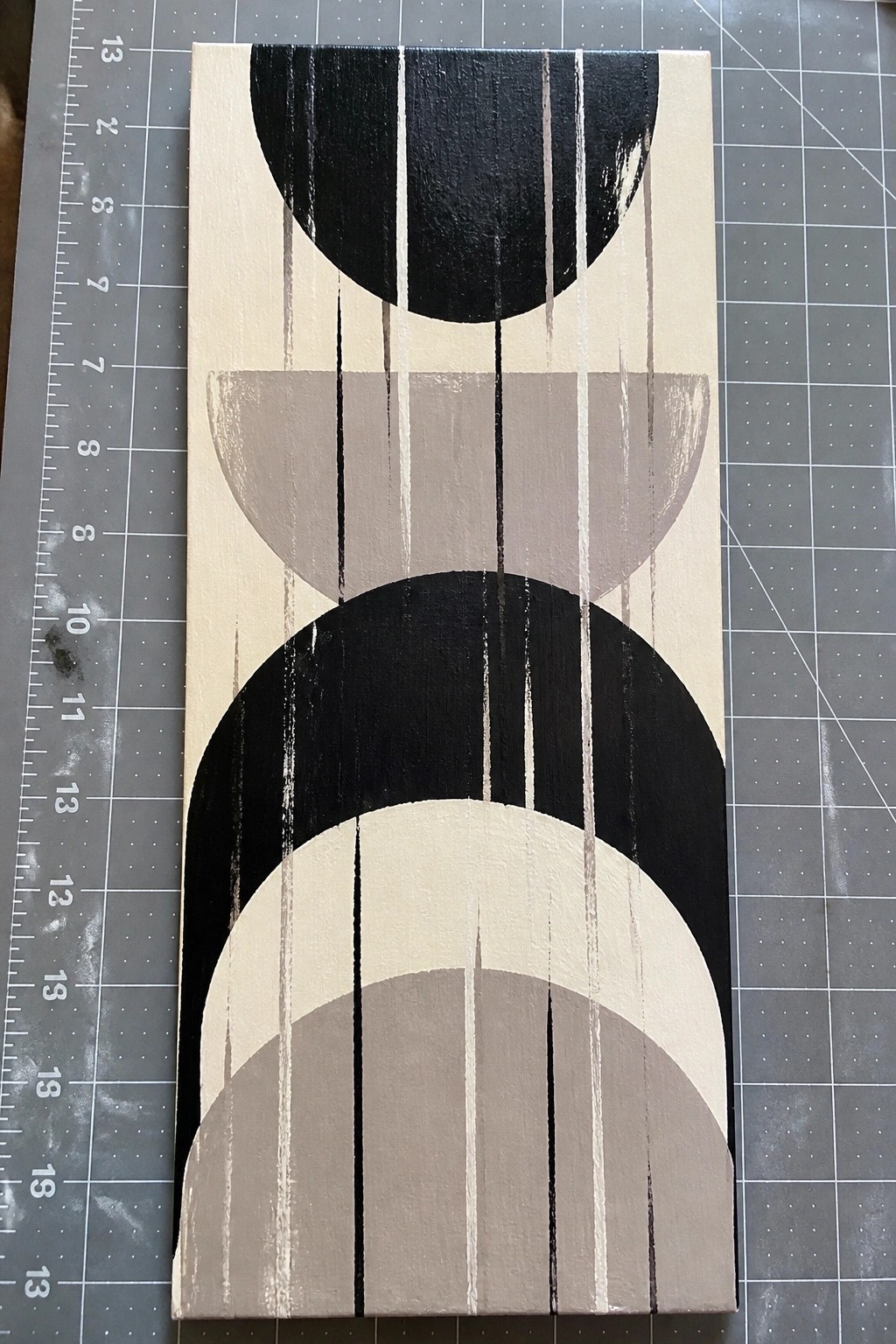 Abstract geometric painting with black and gray semicircles on beige canvas with vertical lines