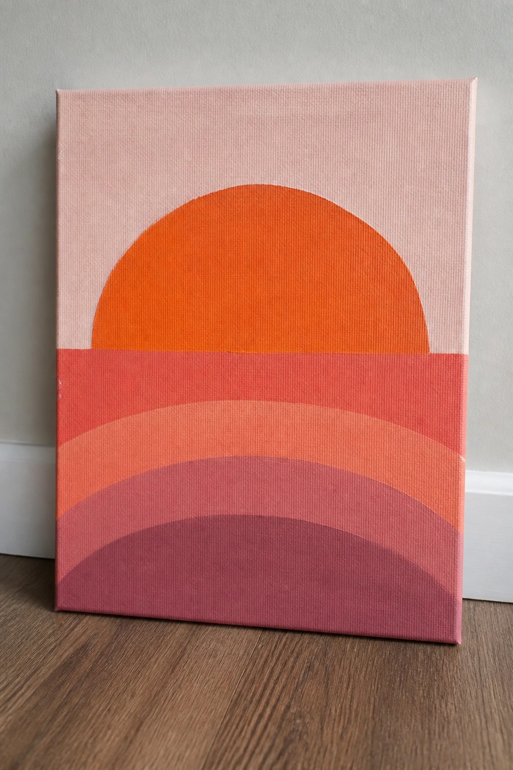 Abstract painting on canvas with orange semicircle above curved red and pink bands.