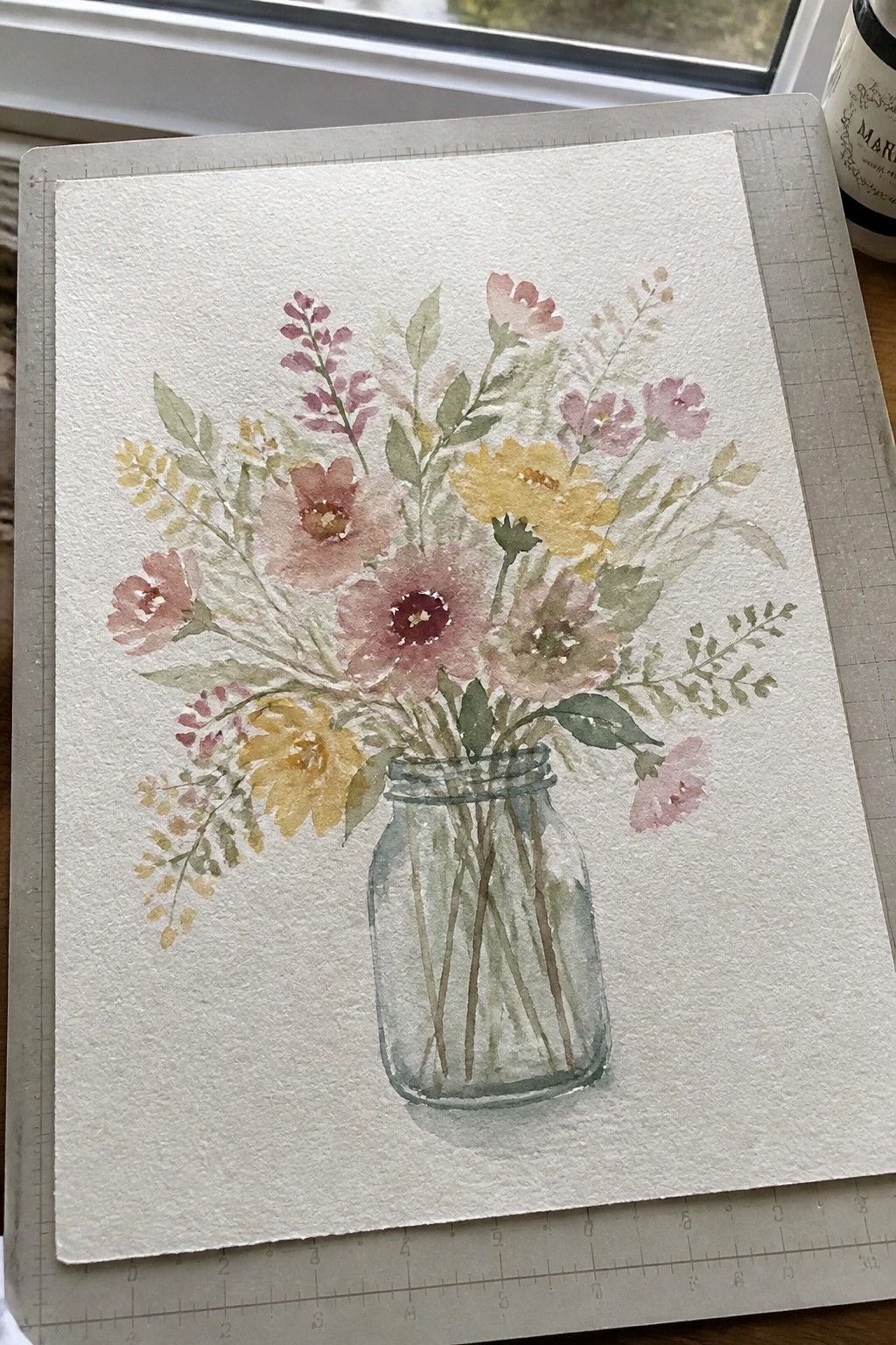 Watercolor painting of pink and yellow flowers in a clear glass mason jar on paper
