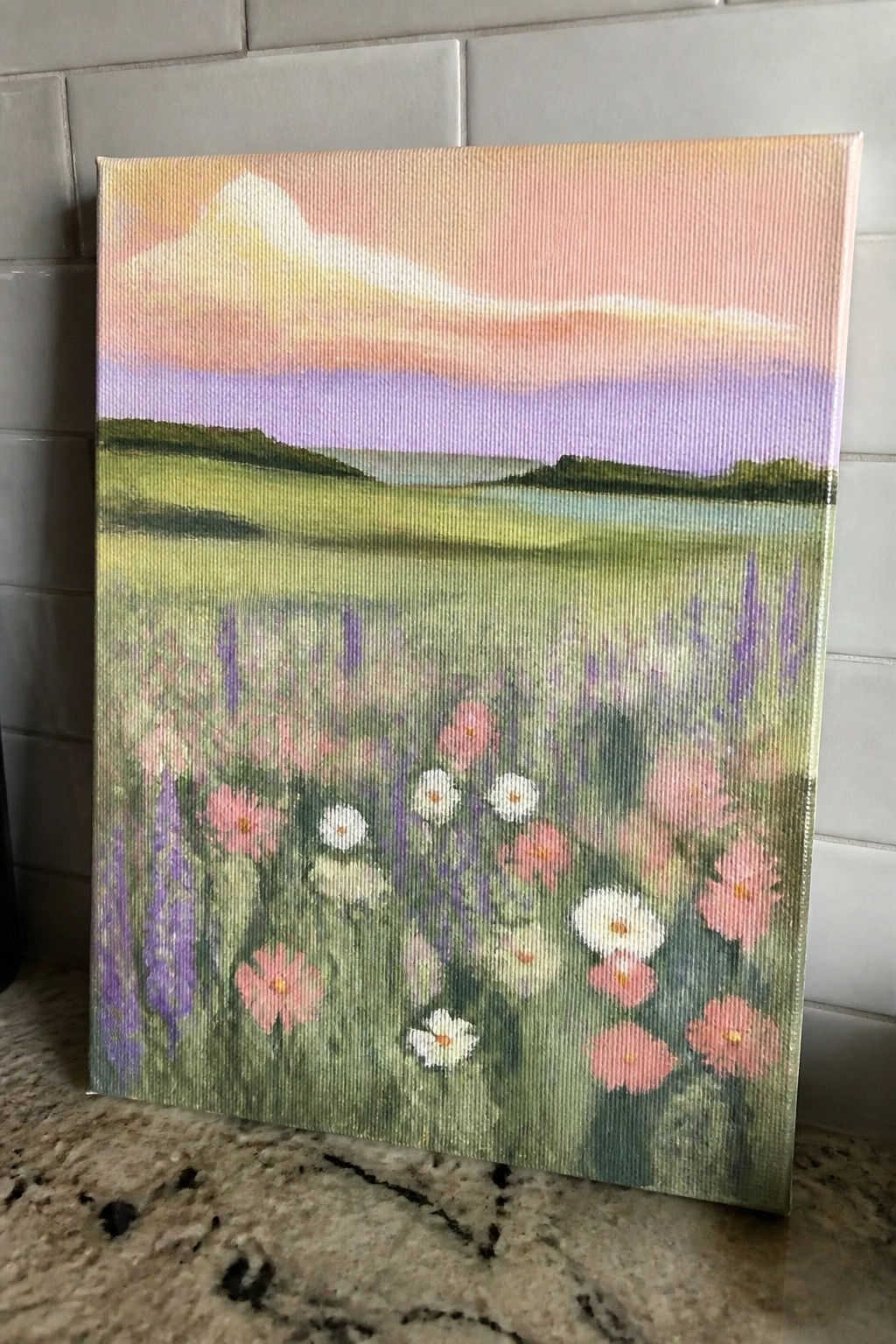 Vibrant painting of wildflowers in a meadow beneath a pink and purple sunset sky