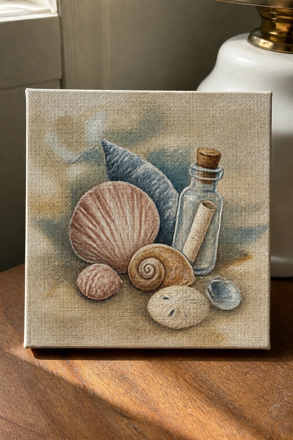 Small canvas painting of seashells, sand dollar, and corked bottle with scroll