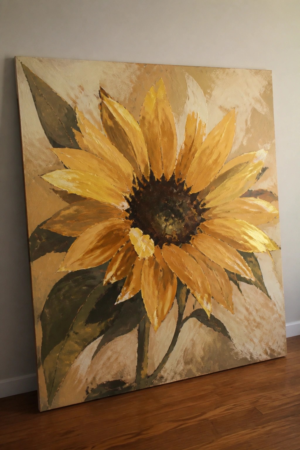 Large abstract sunflower painting in yellow tones leaning against wall on floor