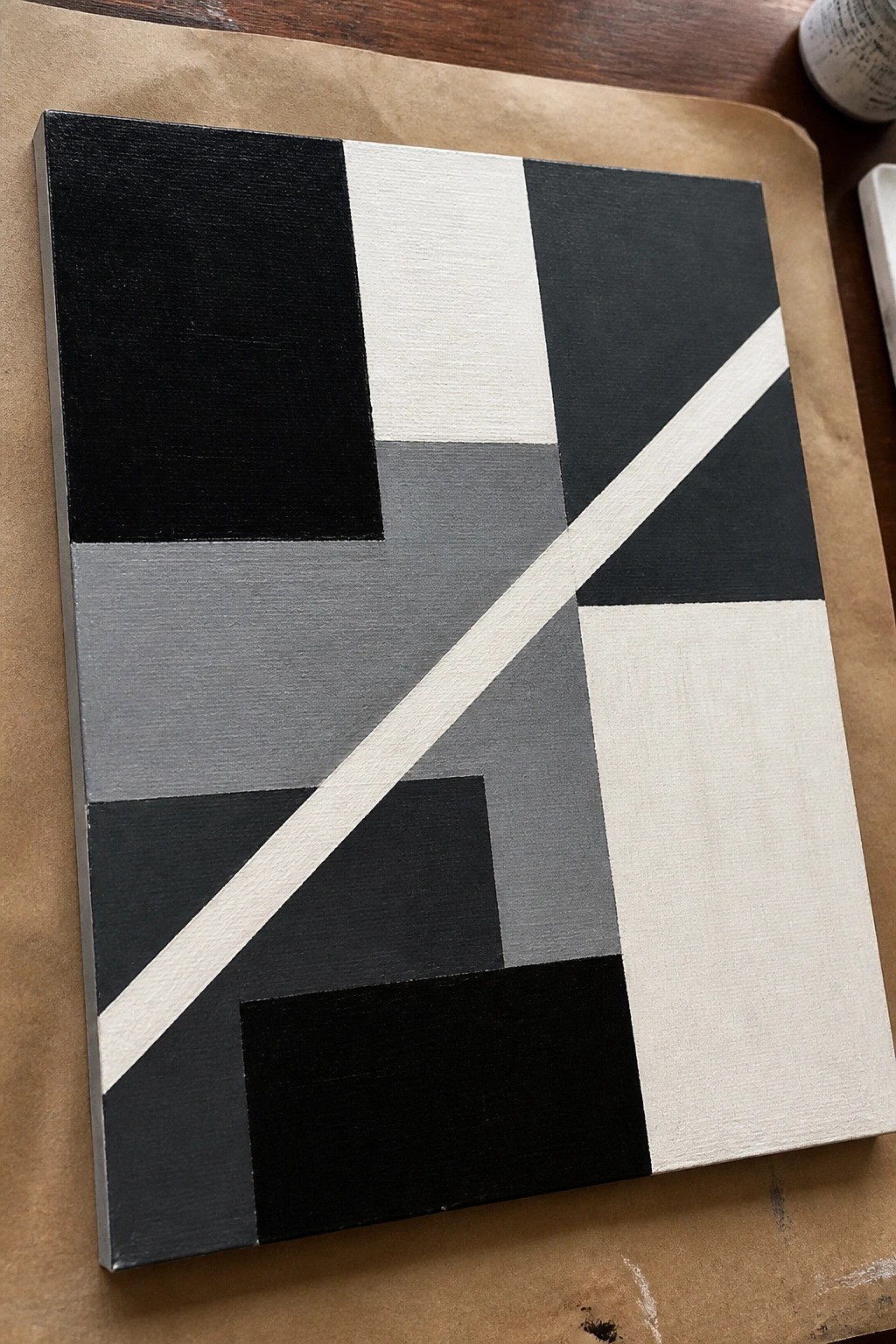 Abstract geometric painting with black, white and gray rectangles and diagonal white stripe