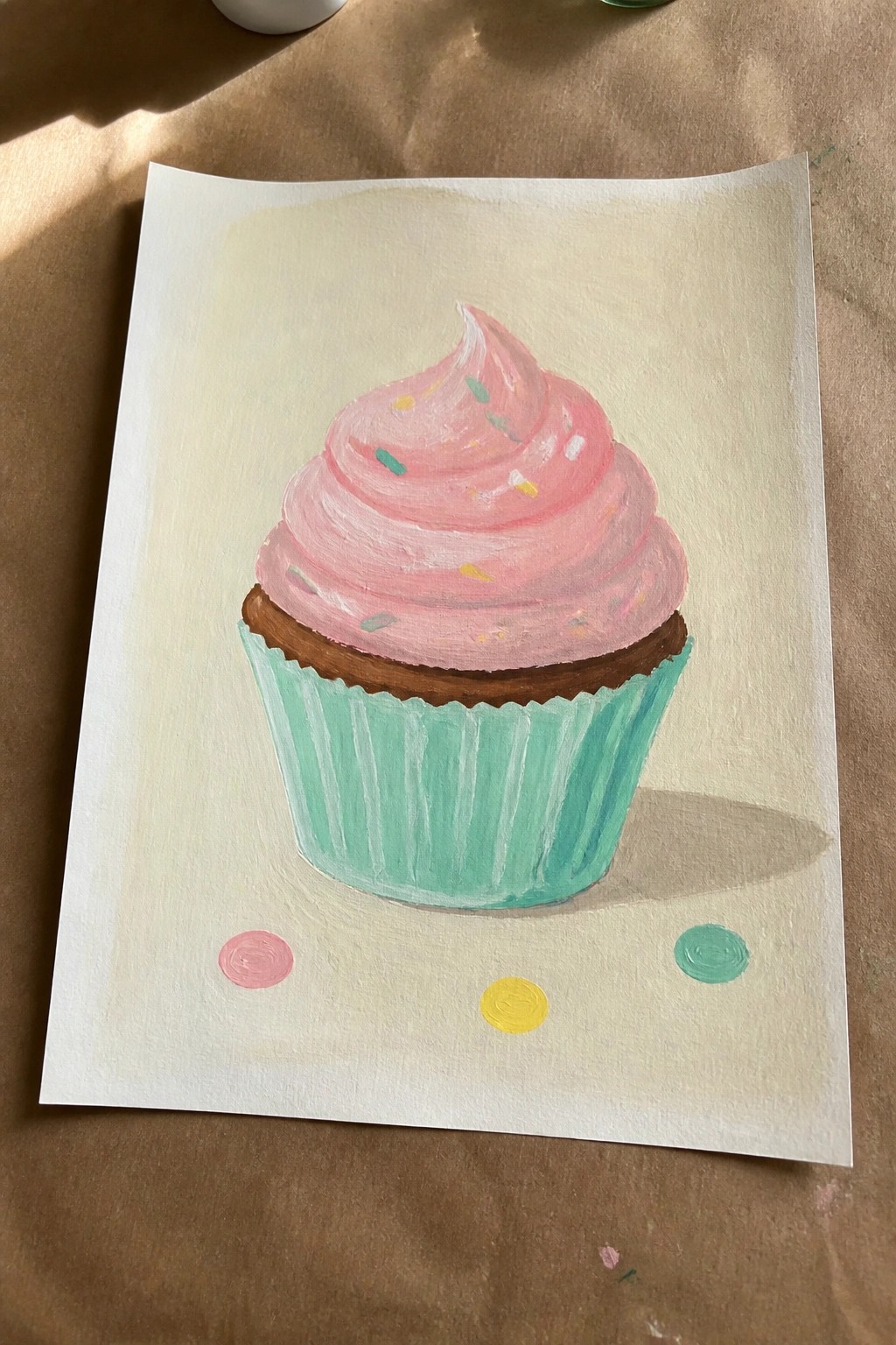 Acrylic painting of pink-frosted cupcake with sprinkles in mint green liner