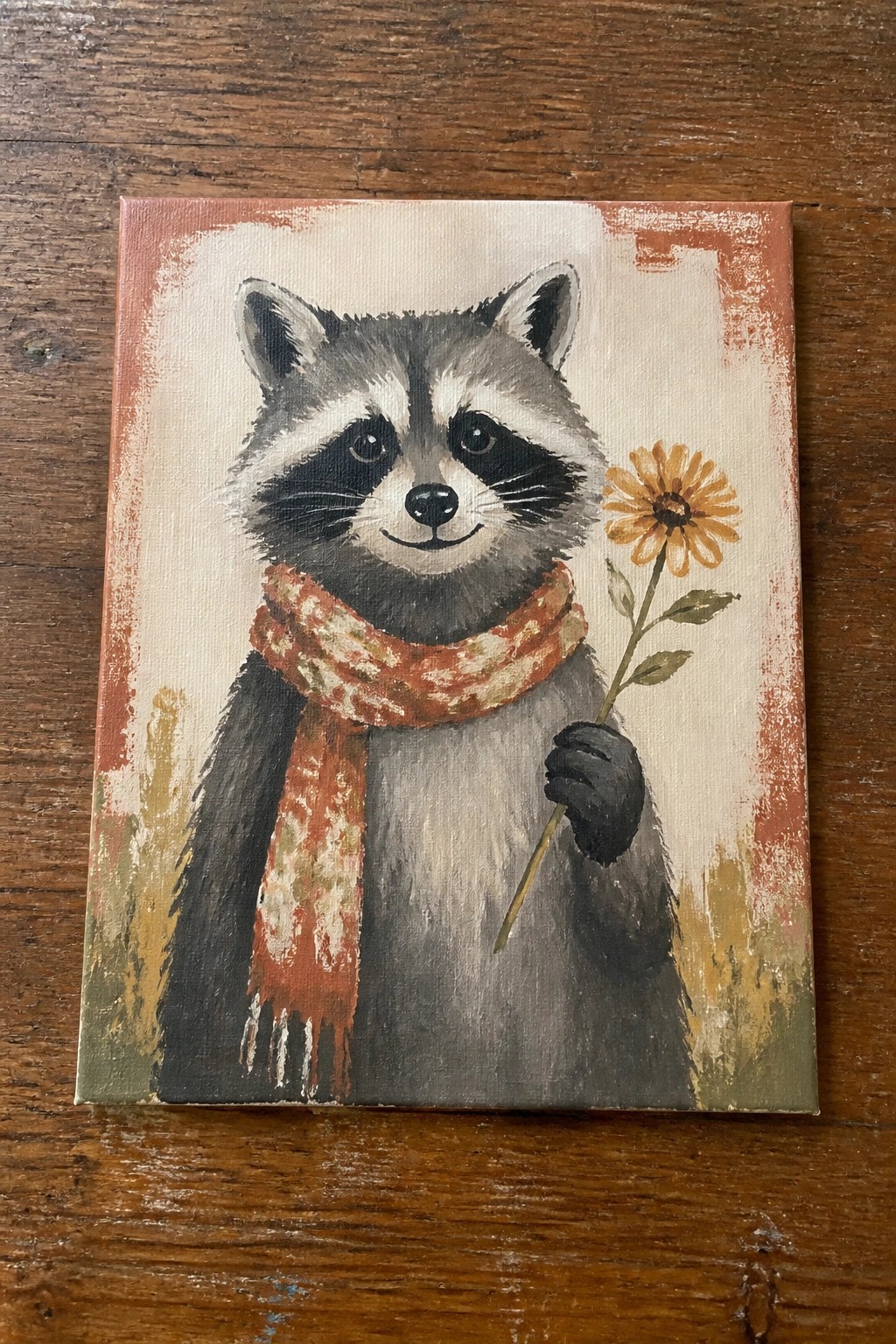 Raccoon in red scarf holds yellow flower on textured canvas with rustic borders