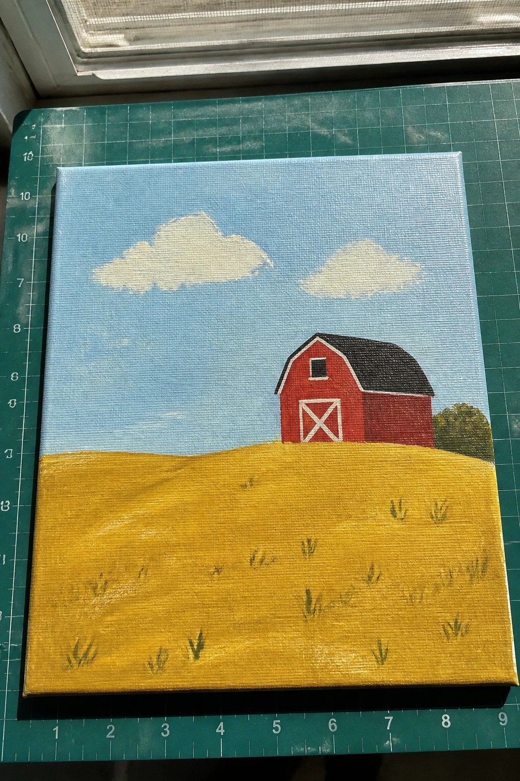 Red barn on yellow field under blue sky with white clouds on canvas