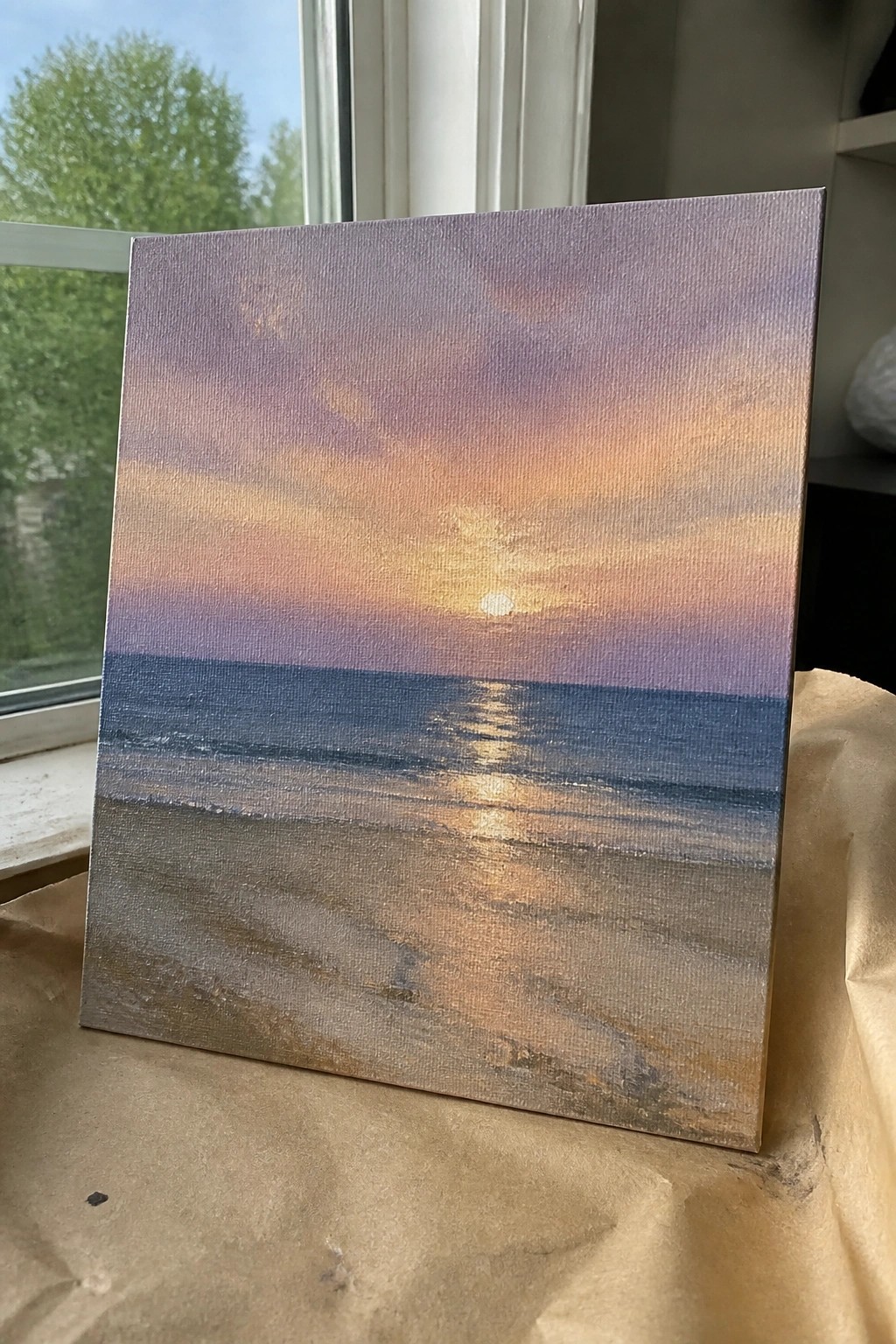 An oil painting of a sunset over the ocean with the sun's reflection on the water and a sandy beach in the foreground.