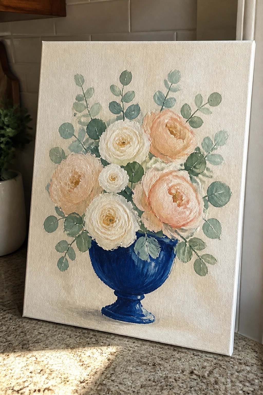 Canvas painting of white and peach roses in blue vase with green leaves