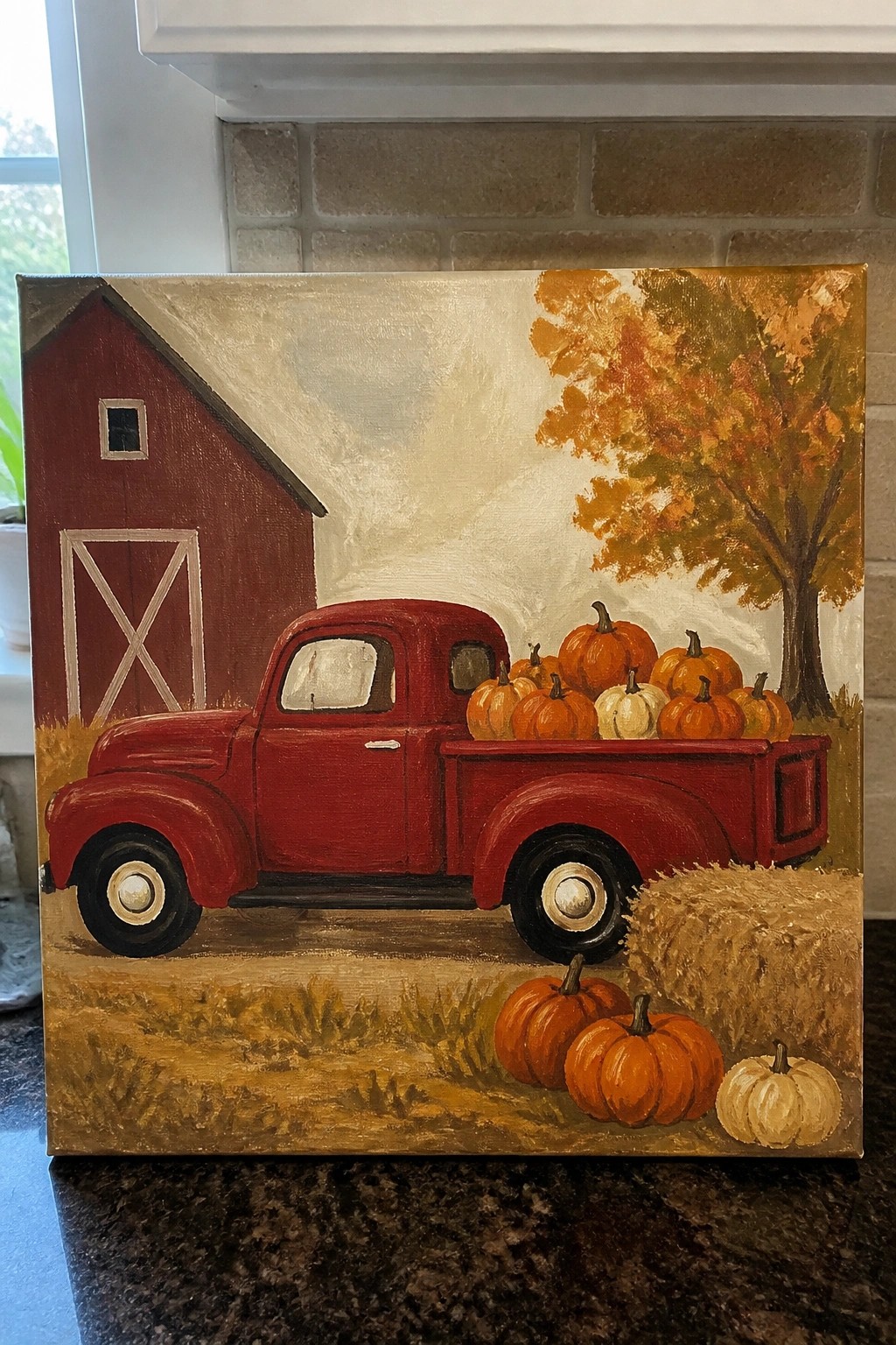 Vintage red truck loaded with pumpkins beside a red barn amid fall foliage