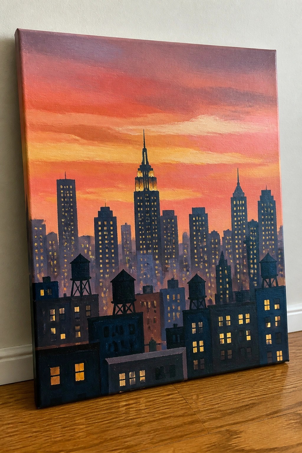 Cityscape painting of skyscrapers against vibrant orange-red sunset sky with lit windows