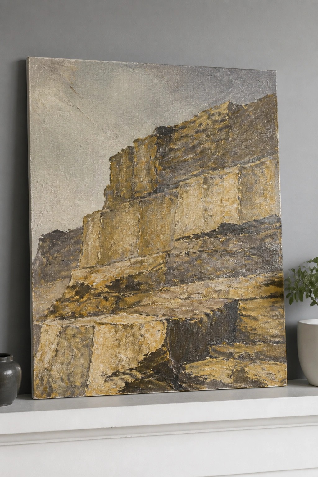 Abstract painting of layered stone blocks in gold, yellow, and gray tones on mantel