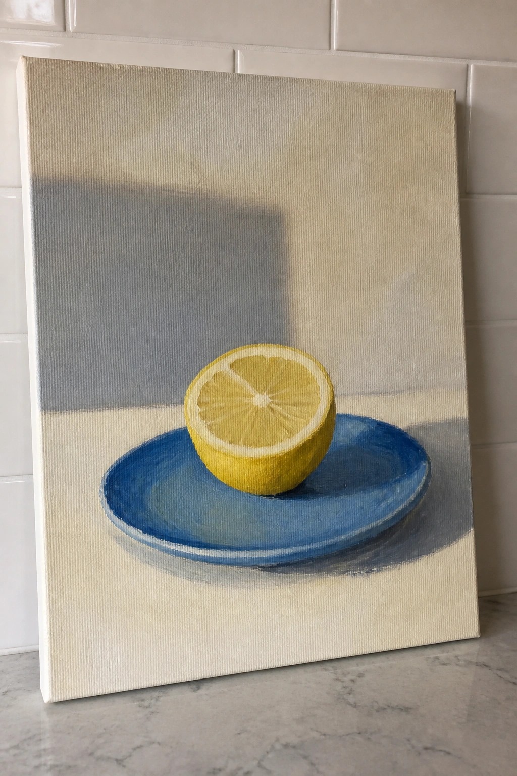 Canvas painting of yellow lemon half on blue plate with soft shadows