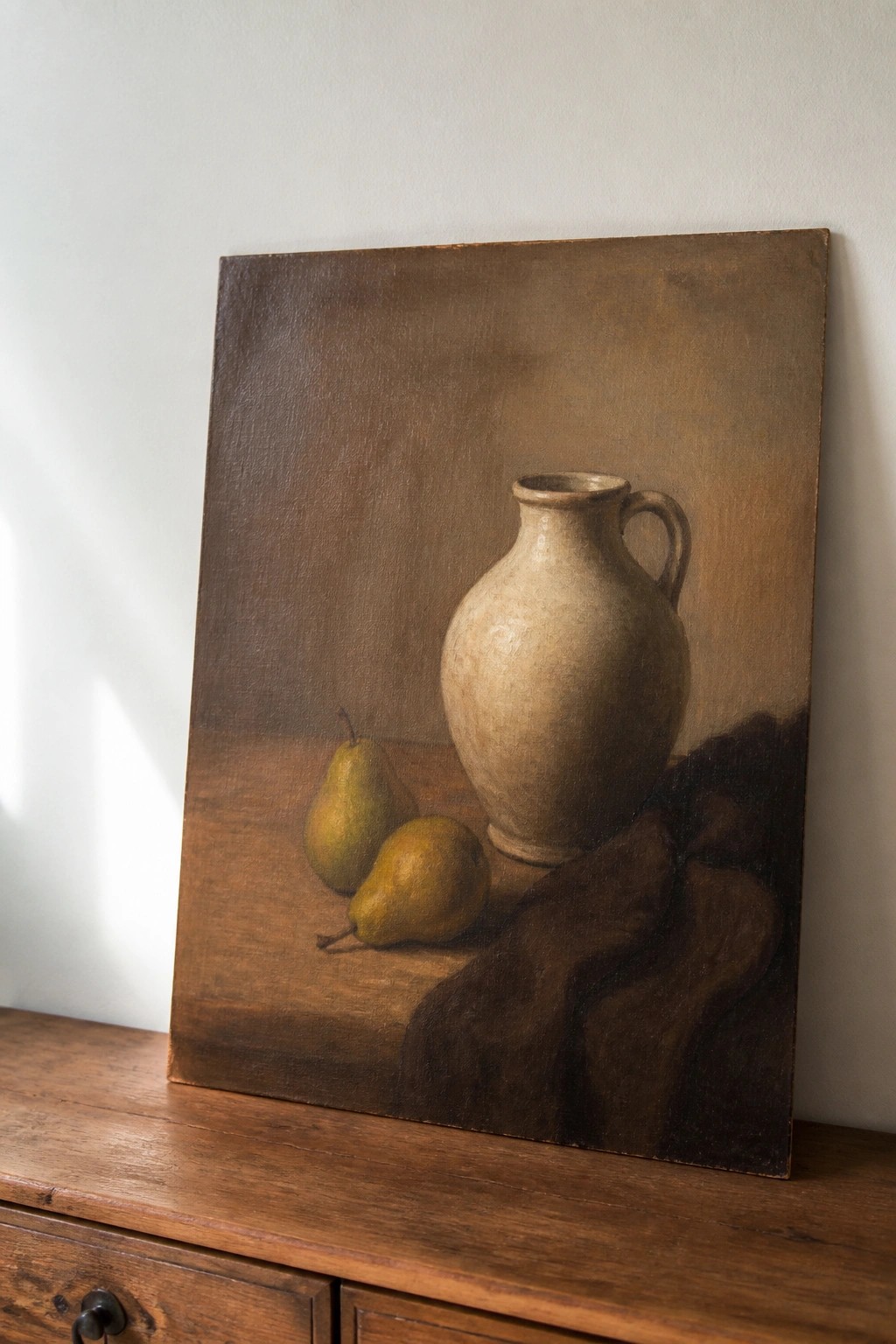 Still life painting of beige pitcher, two pears, and dark fabric on wood.
