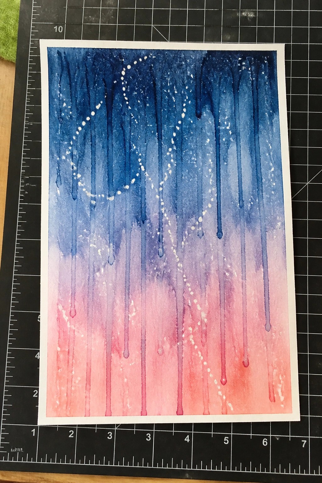 Watercolor with blue-to-pink gradient drips and white dotted constellation patterns on cutting mat