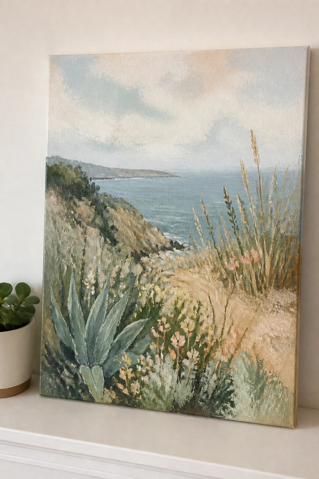 Painting of coastal cliffs with wildflowers overlooking the blue ocean under soft skies