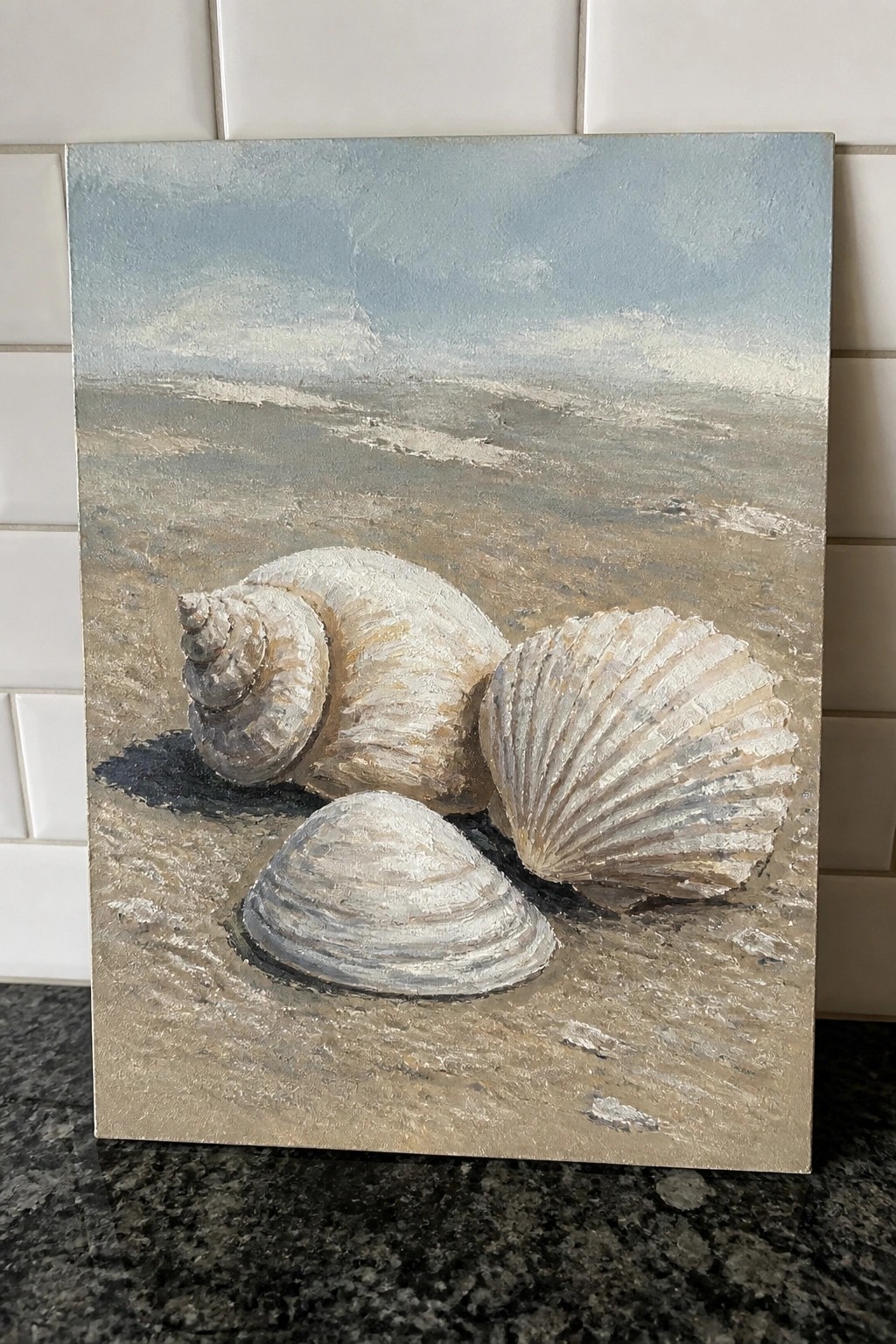 Three seashells on sandy beach with ocean waves and blue sky, textured oil painting.