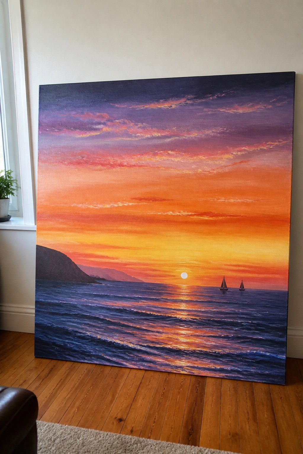Large vibrant sunset painting with two sailboats leaning against indoor wall