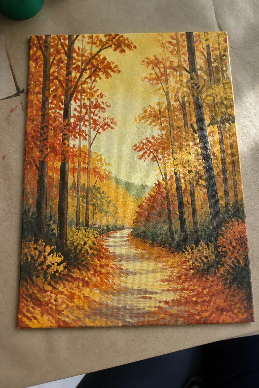 Colorful oil painting of winding path through autumn forest with orange and yellow trees