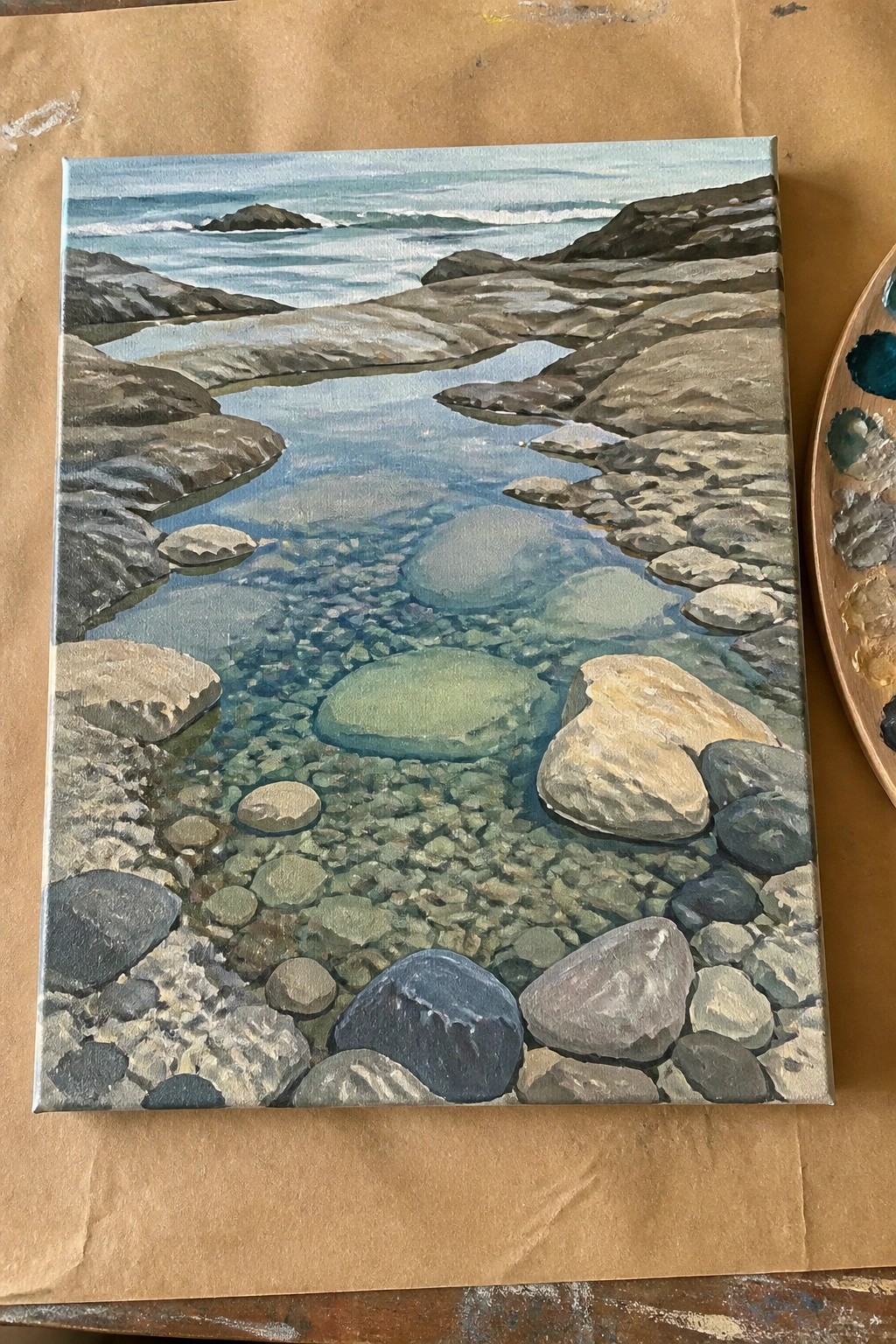 Realistic painting of clear turquoise water over pebbles between rocky cliffs by the sea