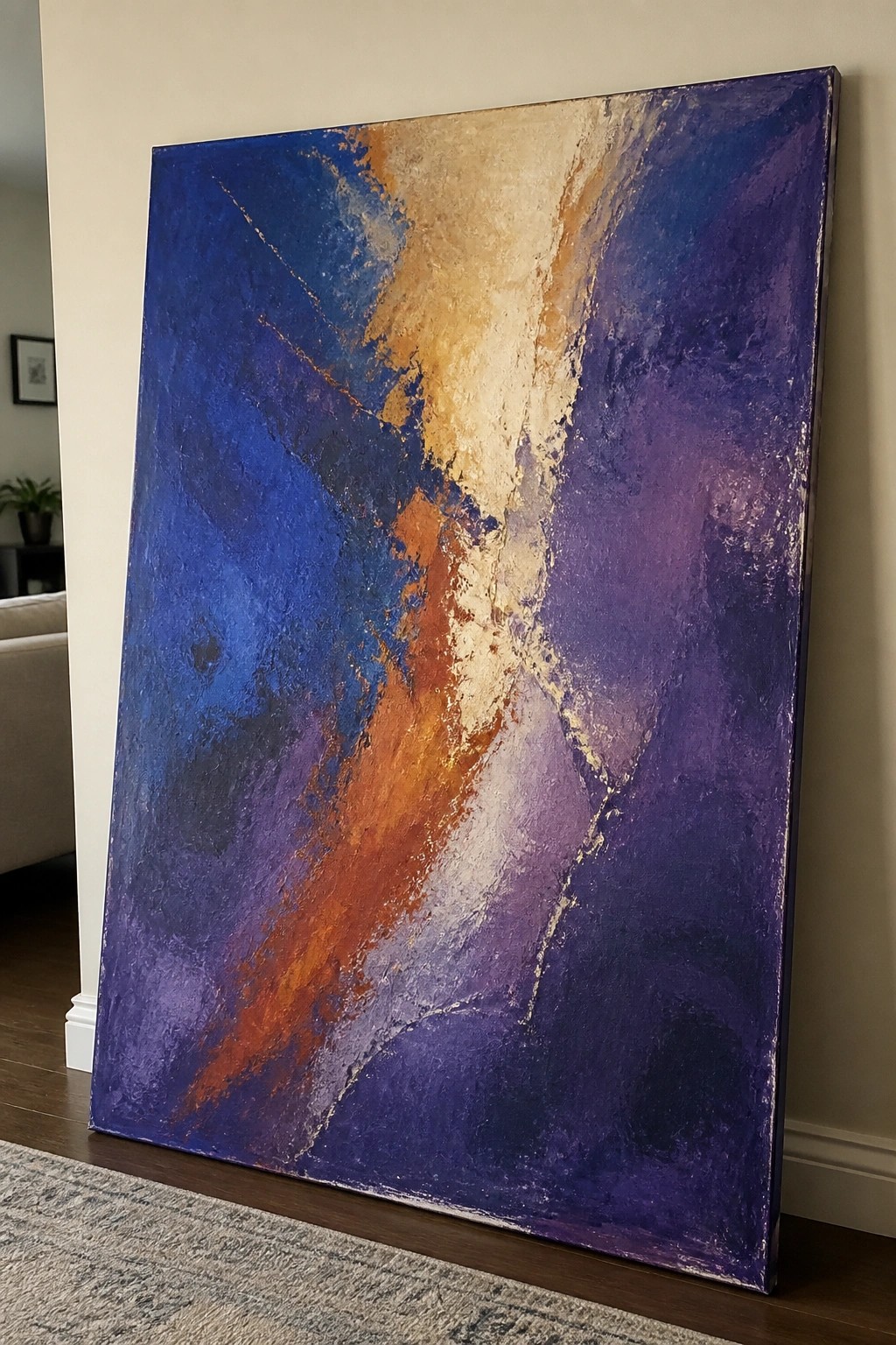Large abstract painting in bold blue purple orange and beige strokes leaning on wall