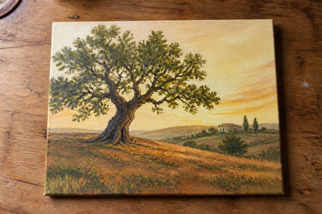 Landscape painting of large tree in golden fields at vibrant sunset with distant hills